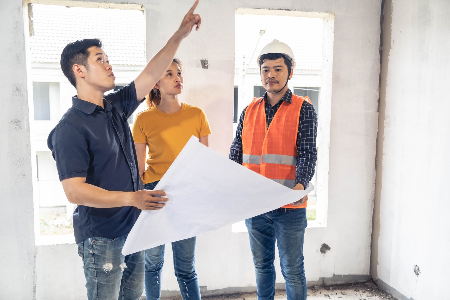 Young asian couple checking house with foreman engineering home inspection building house Walk home inspection with looking and pointing construction for check building home on job site to construction 2021